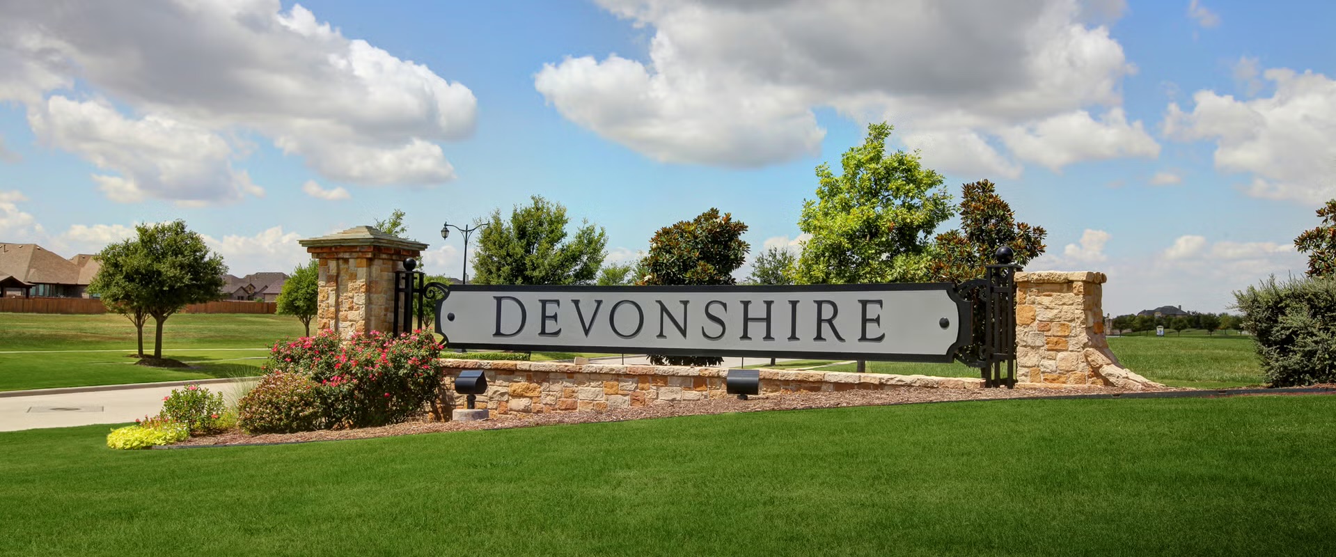 Devonshire community entrance sign with stone columns and landscaping in Forney, Texas