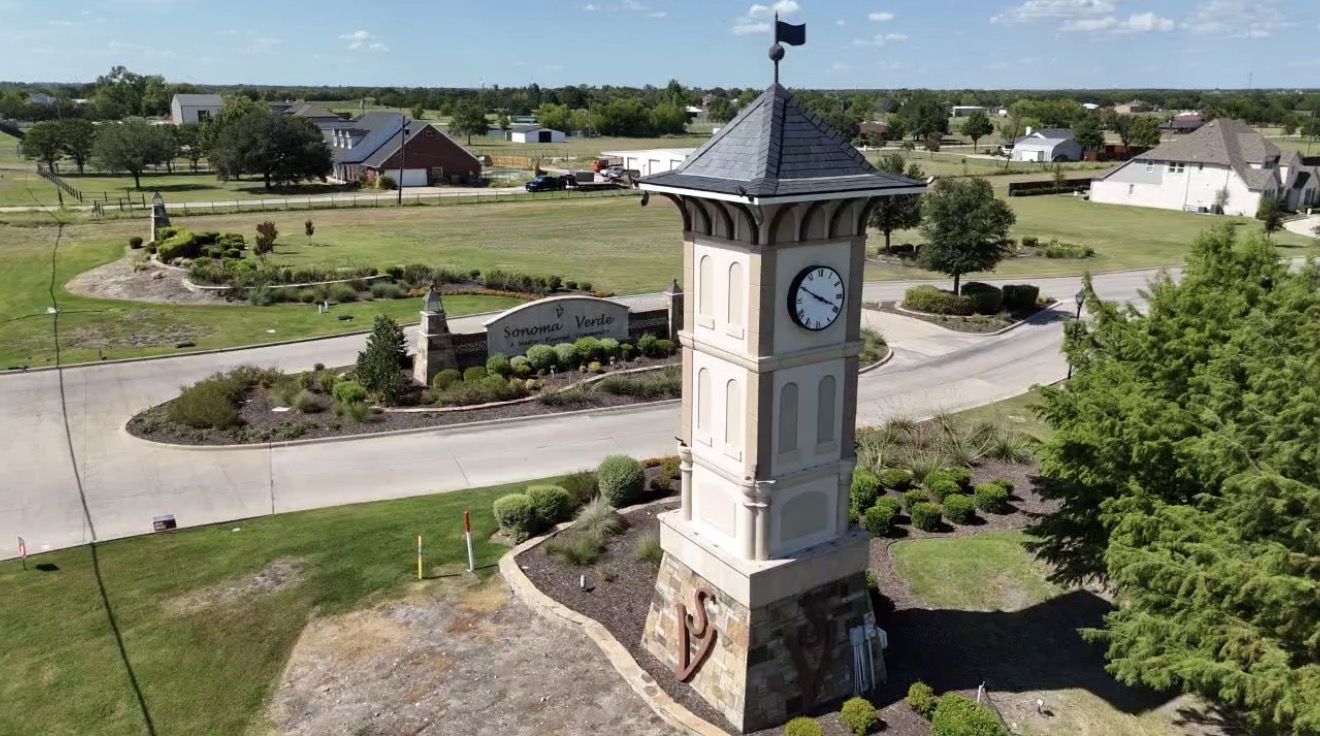 Aerial view of the stone clock tower at the entrance to Sonoma Verde in Rockwall, Texas